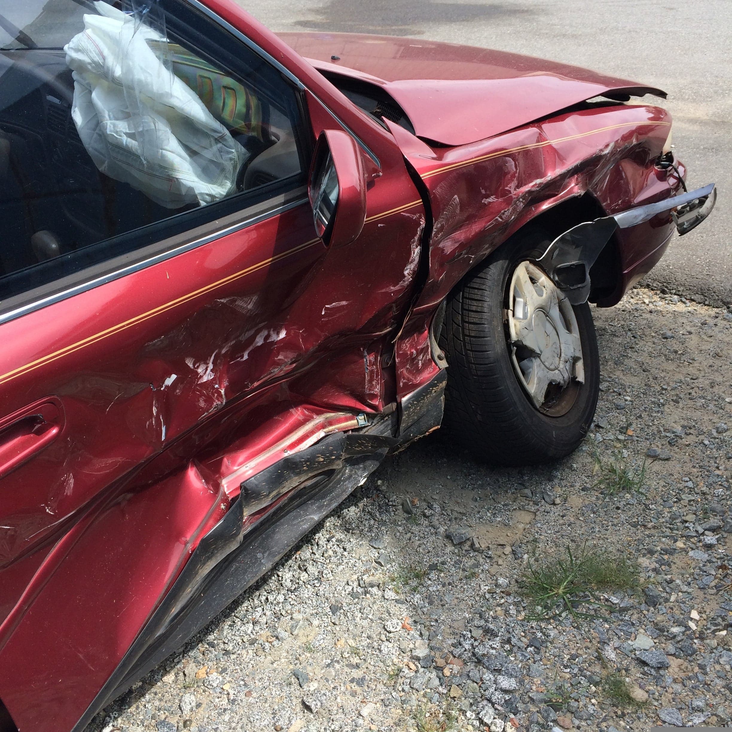 Unfallschaden am Fahrzeug: eingedrückter hinterer Kotflügel und ausgelöster Airbag nach einem Verkehrsunfall